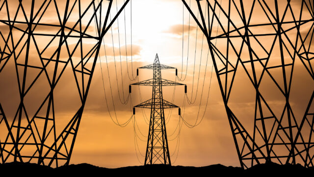 High voltage towers at sunset background. Power lines against the sky